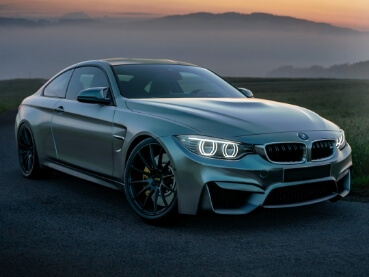 自然の中に停車した高級スポーツカーの横顔