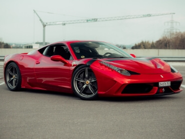 曇り空の下に佇む鮮烈な赤色のスーパーカー