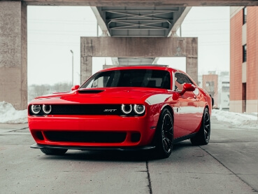 橋の下に駐車された真紅のアメリカンスポーツカー